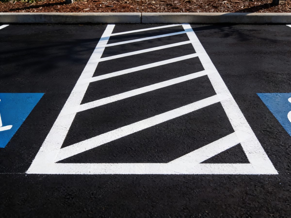 Freshly painted white parking stall lines on newly sealed black asphalt